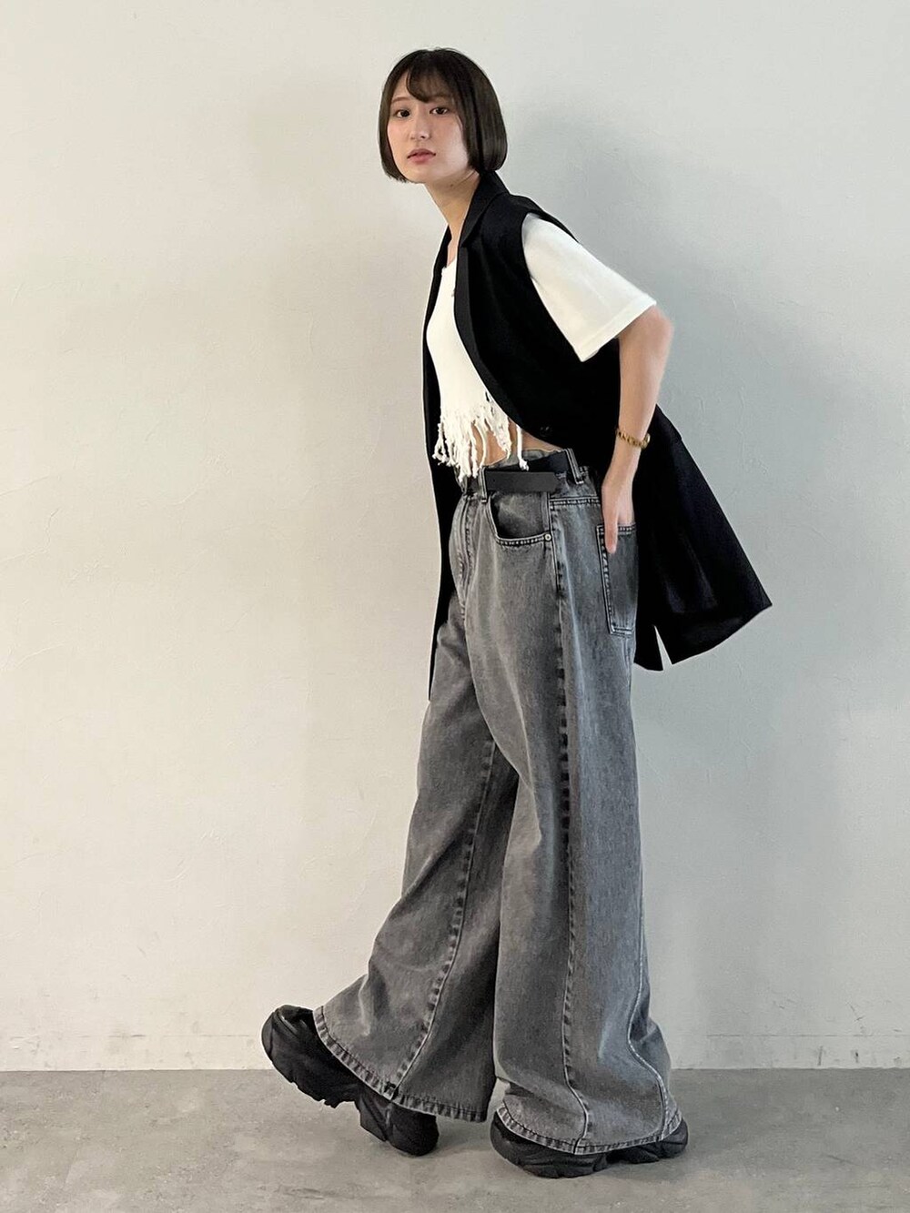 ブラック系のスニーカー、ブラック系のデニムパンツ、ブラック系のその他アウターを着用したレディースの春コーディネートの3枚目の写真