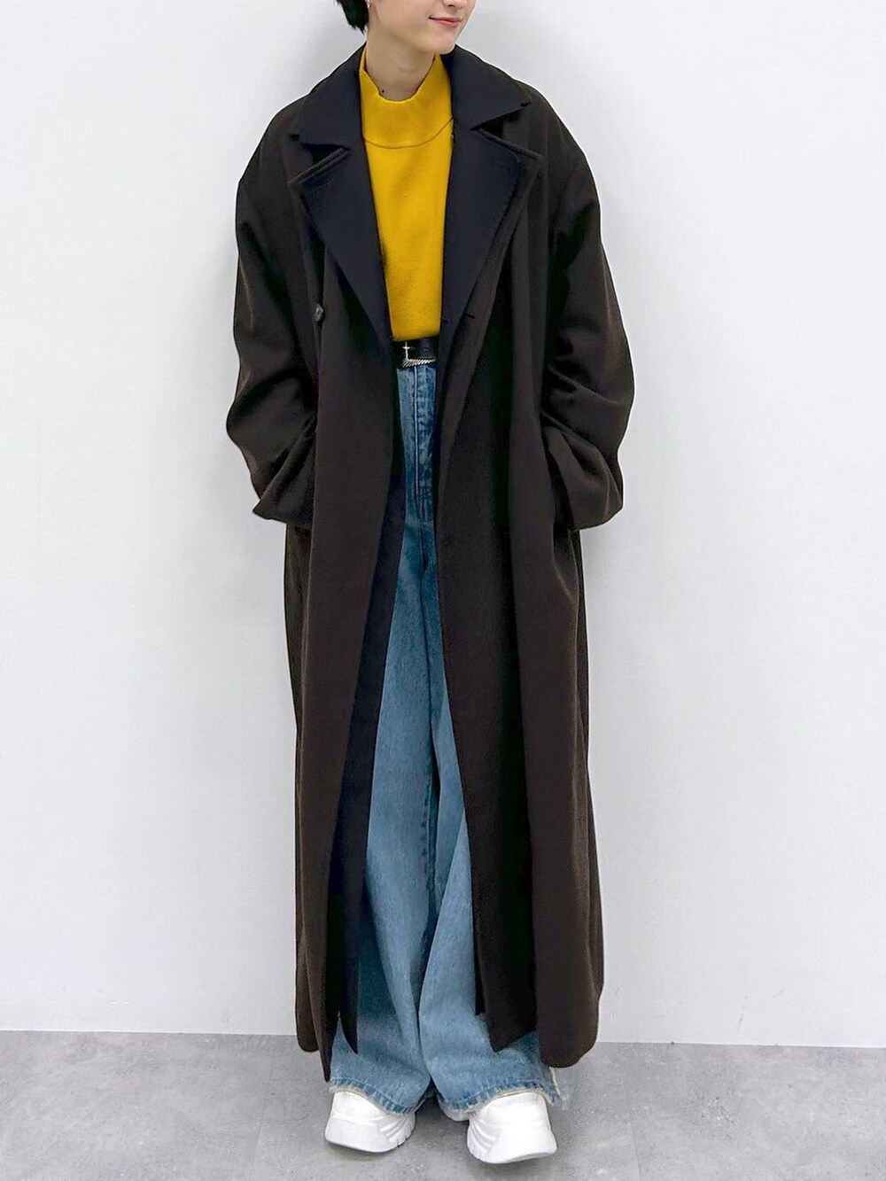 イエロー系のニット/セーター、ブルー系のデニムパンツ、ブラウン系のその他アウターを着用したレディースの秋コーディネートの2枚目の写真