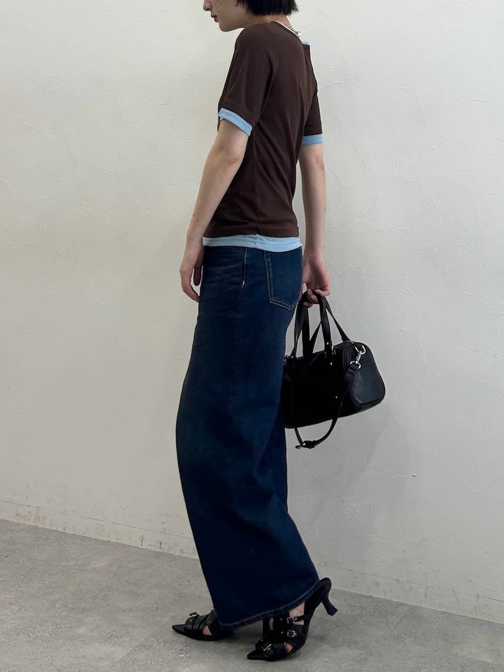 ブルー系のデニムパンツ、ブラック系のサンダル、ブラウン系のTシャツ/カットソーを着用したレディースの春コーディネートの5枚目の写真
