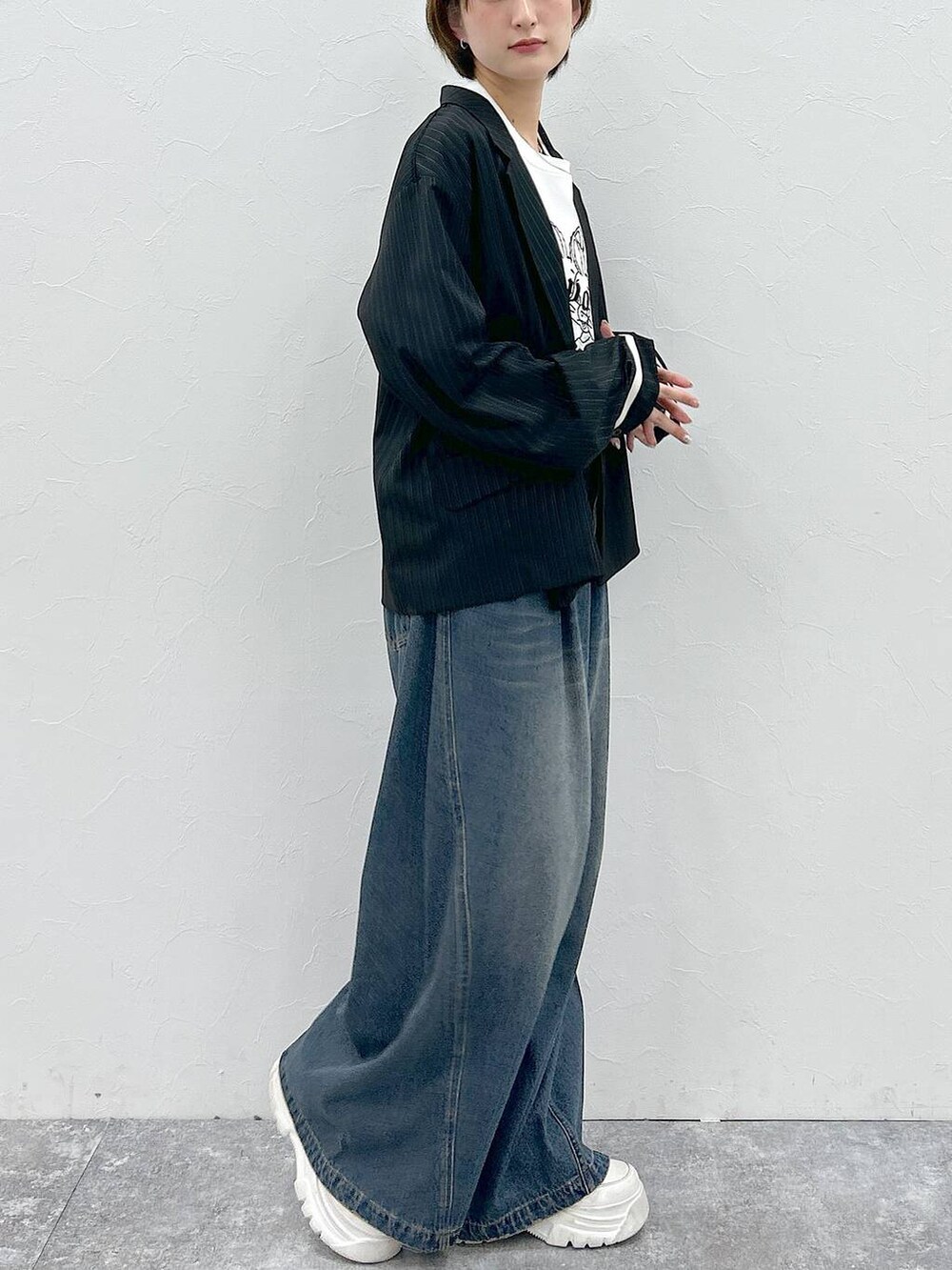 ブルー系のデニムパンツ、ホワイト系のTシャツ/カットソー、ブラック系のテーラードジャケットを着用したレディースの春コーディネートの5枚目の写真