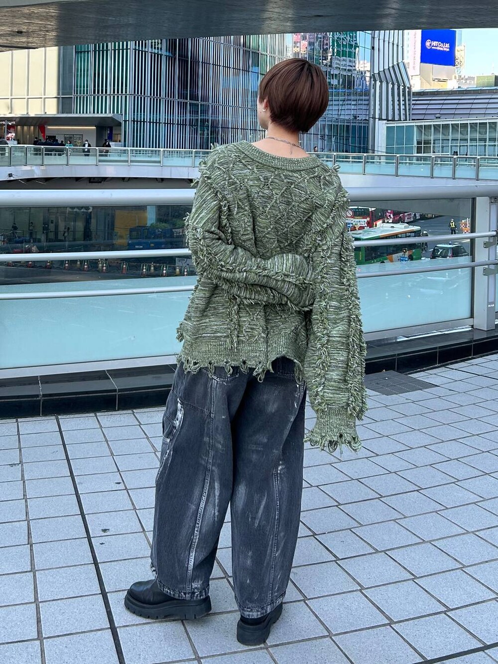 グリーン系のニット/セーター、ブラック系のデニムパンツを着用したレディースの冬コーディネートの6枚目の写真