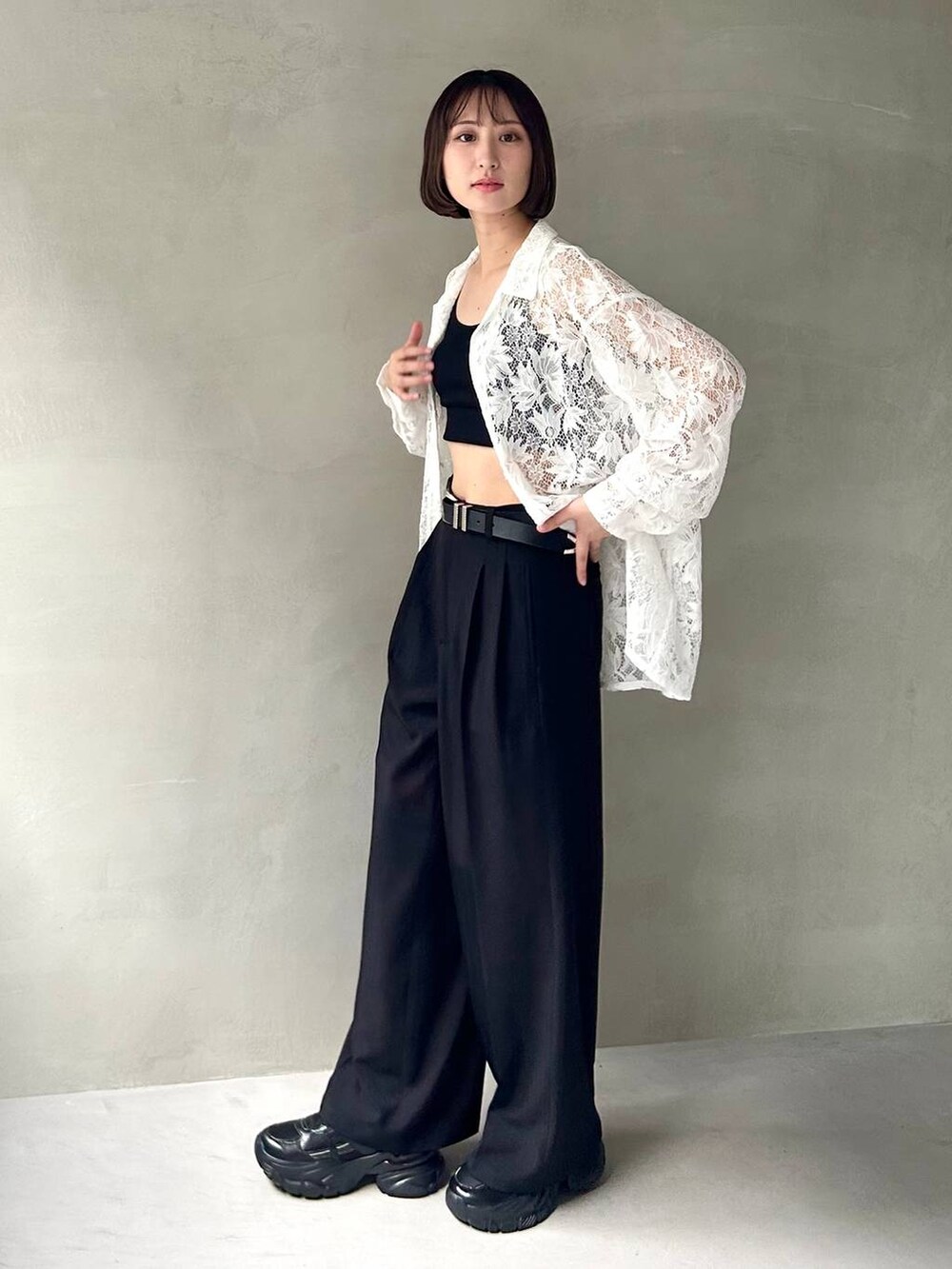 ブラック系のキャミソール、ブラック系のスラックス、ブラック系のスニーカーを着用したレディースの夏コーディネートの3枚目の写真