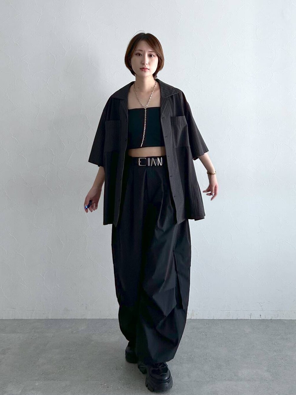 ブラック系のシャツ/ブラウス、ブラック系のカーゴパンツ、ブラック系のベルトを着用したレディースの春コーディネートの2枚目の写真