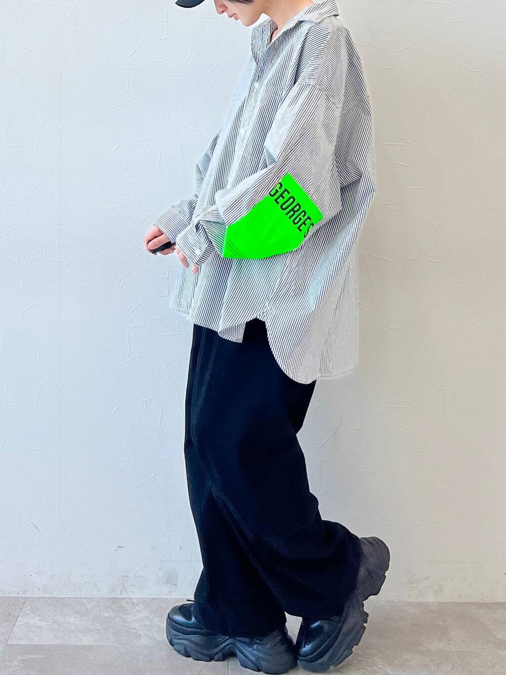 ブラック系のスニーカー、ブラック系のチノパンツ、ブラック系のキャップを着用したレディースの春コーディネートの4枚目の写真