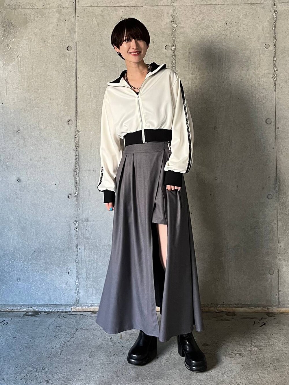 ブラック系のキャミソール、ブラック系のブーツ、グレー系のスカートを着用したレディースの冬コーディネートの7枚目の写真