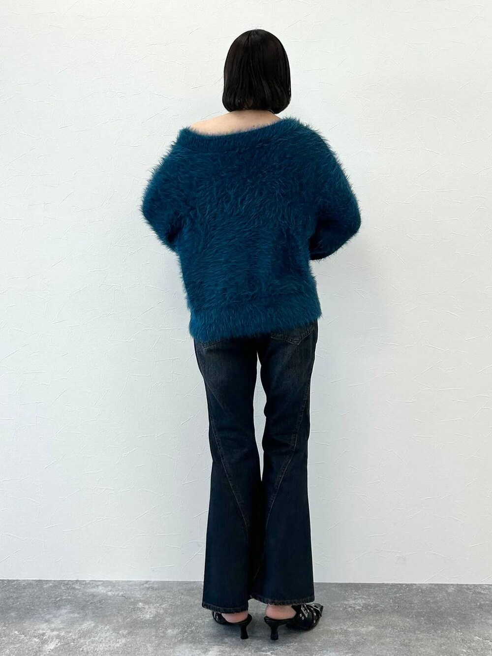 ブルー系のデニムパンツ、ブラック系のパンプス、ブルー系のニット/セーターを着用したレディースの秋コーディネートの6枚目の写真