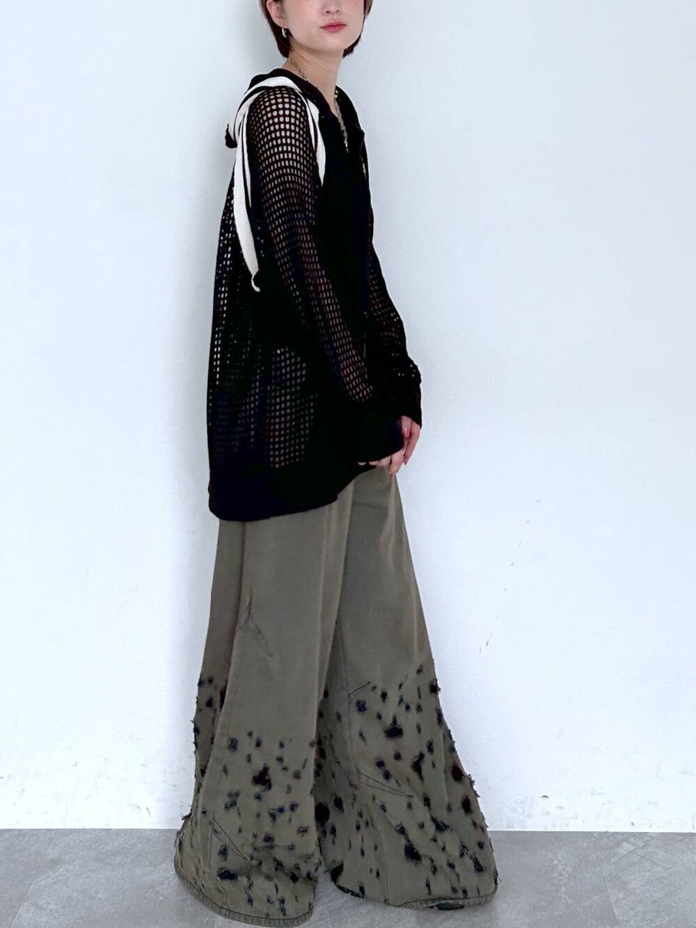 ブラック系のデニムパンツ、ブラック系のパーカー、シルバー系のピアス（両耳用）を着用したレディースの夏コーディネートの4枚目の写真