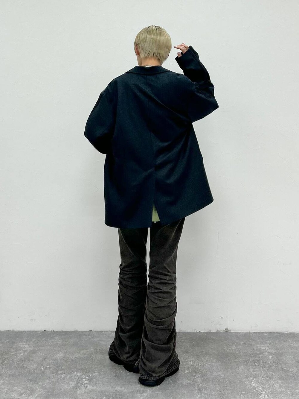 ブラック系のデニムパンツ、ブラック系のテーラードジャケット、グリーン系のニット/セーターを着用したレディースの秋コーディネートの6枚目の写真