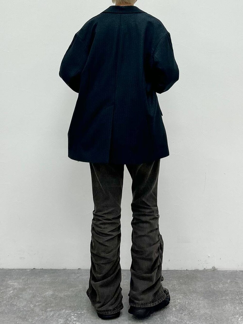 ブラック系のデニムパンツ、ブラック系のテーラードジャケット、グリーン系のニット/セーターを着用したレディースの秋コーディネートの7枚目の写真