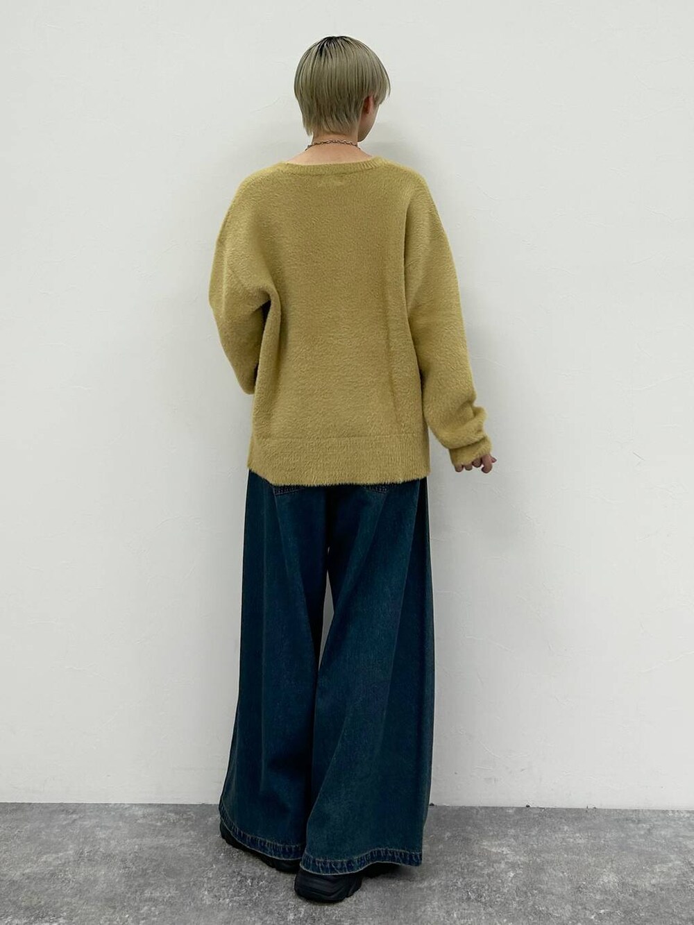 ブラック系のスニーカー、ブルー系のデニムパンツ、イエロー系のニット/セーターを着用したレディースの春コーディネートの8枚目の写真