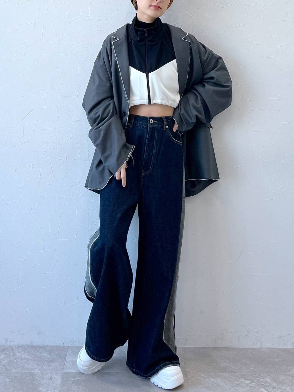 ブルー系のデニムパンツ、グレー系のテーラードジャケット、ブラック系のナイロンジャケットを着用したレディースの秋コーディネートの4枚目の写真