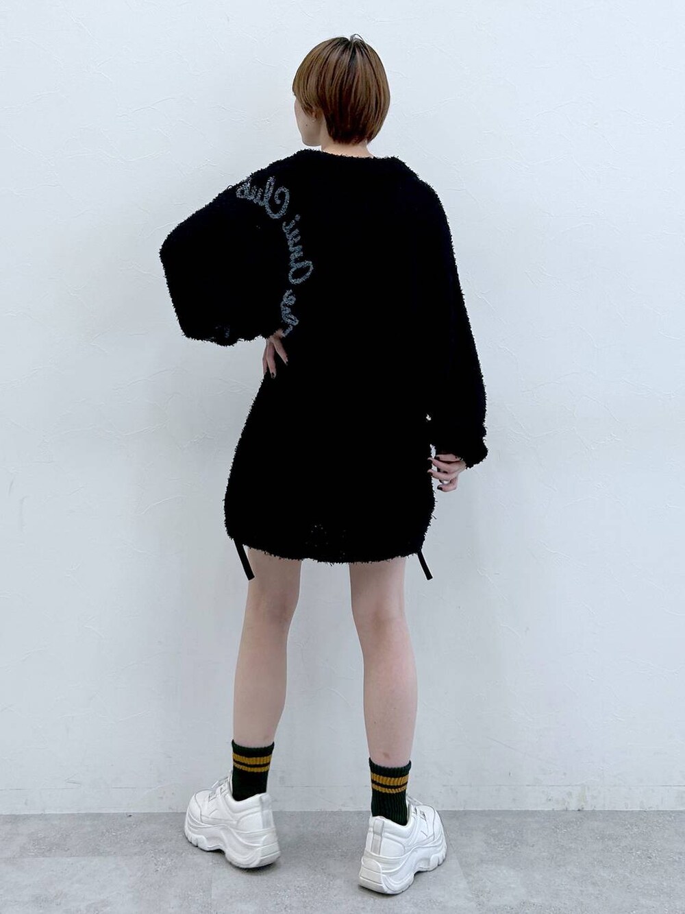 ブラック系のニット/セーターを着用したレディースの春コーディネートの8枚目の写真