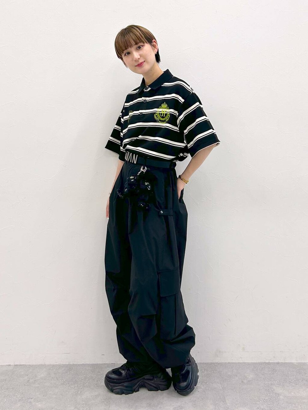 ブラック系のスニーカー、ブラック系のカーゴパンツ、ブラック系のTシャツ/カットソーを着用したレディースの夏コーディネートの4枚目の写真