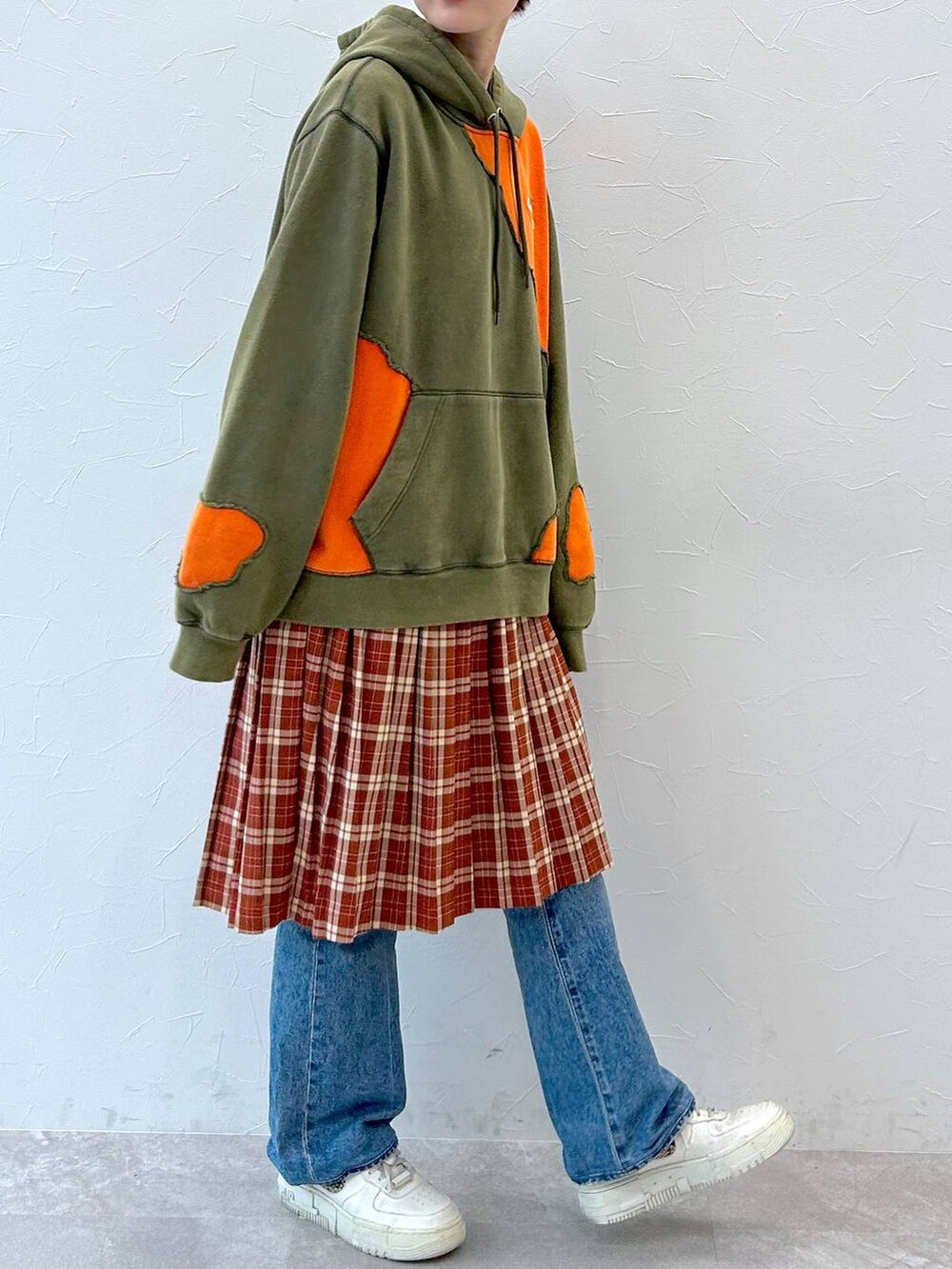 グリーン系のパーカー、レッド系のスカートを着用したレディースの秋コーディネートの3枚目の写真