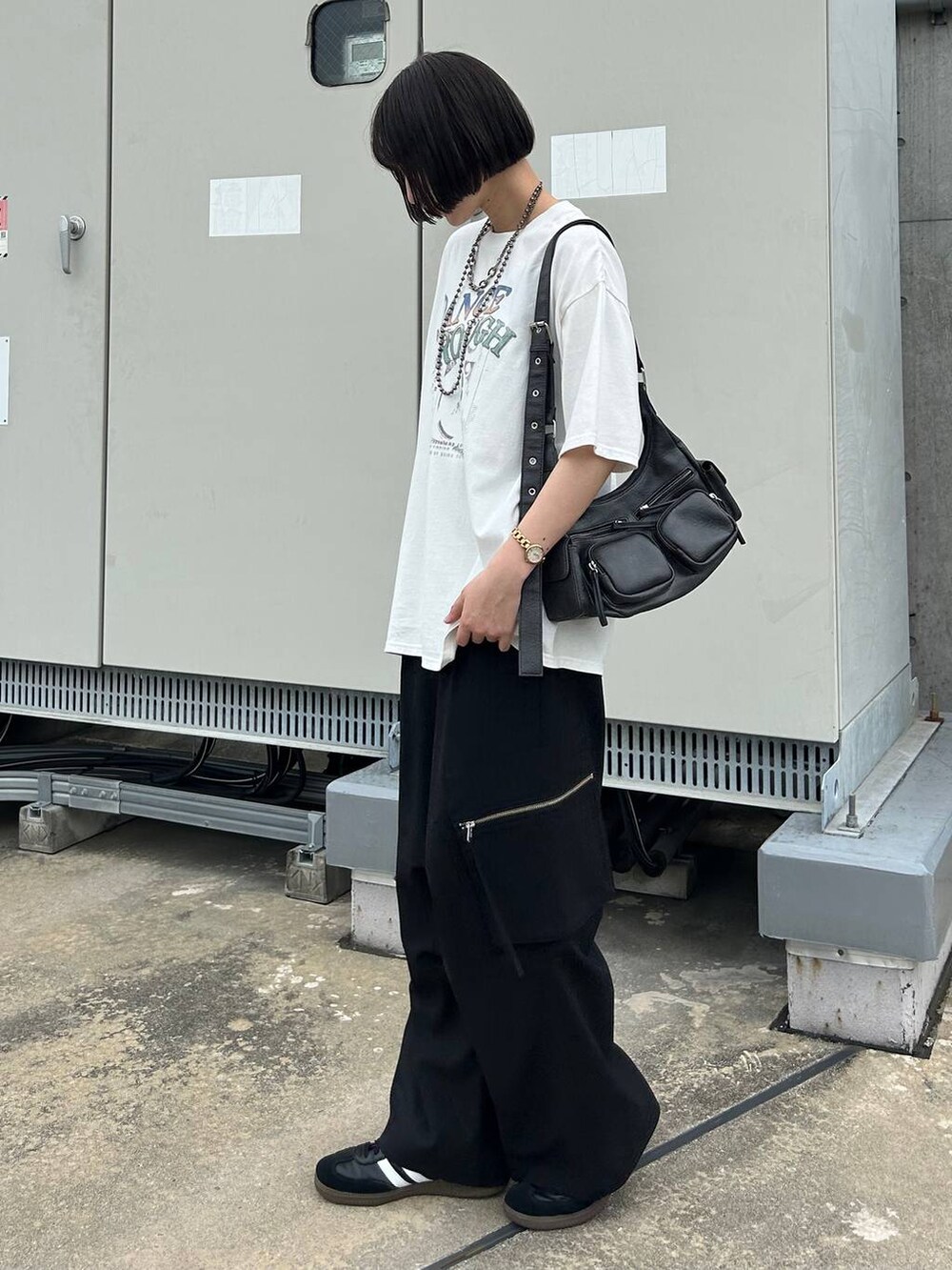 ブラック系のカーゴパンツ、ブラック系のショルダーバッグ、ホワイト系のTシャツ/カットソーを着用したレディースの夏コーディネートの4枚目の写真