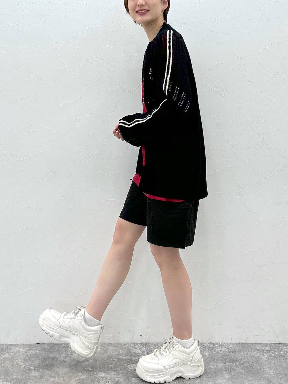 ブラック系のカーディガン/ボレロ、レッド系のTシャツ/カットソー、ブラック系のカーゴパンツを着用したレディースの春コーディネートの4枚目の写真