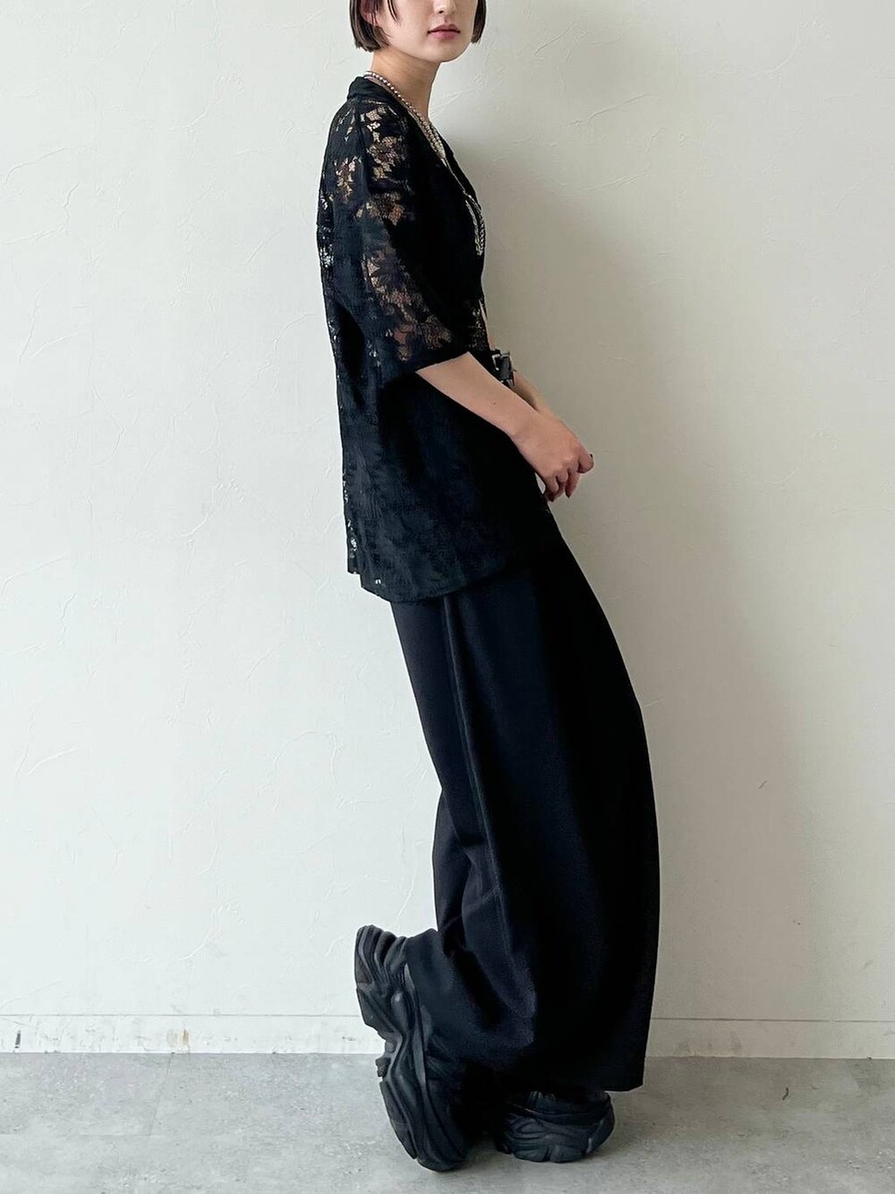 ブラック系のスニーカー、ブラック系のキャミソール、ブラック系のスラックスを着用したレディースの夏コーディネートの5枚目の写真