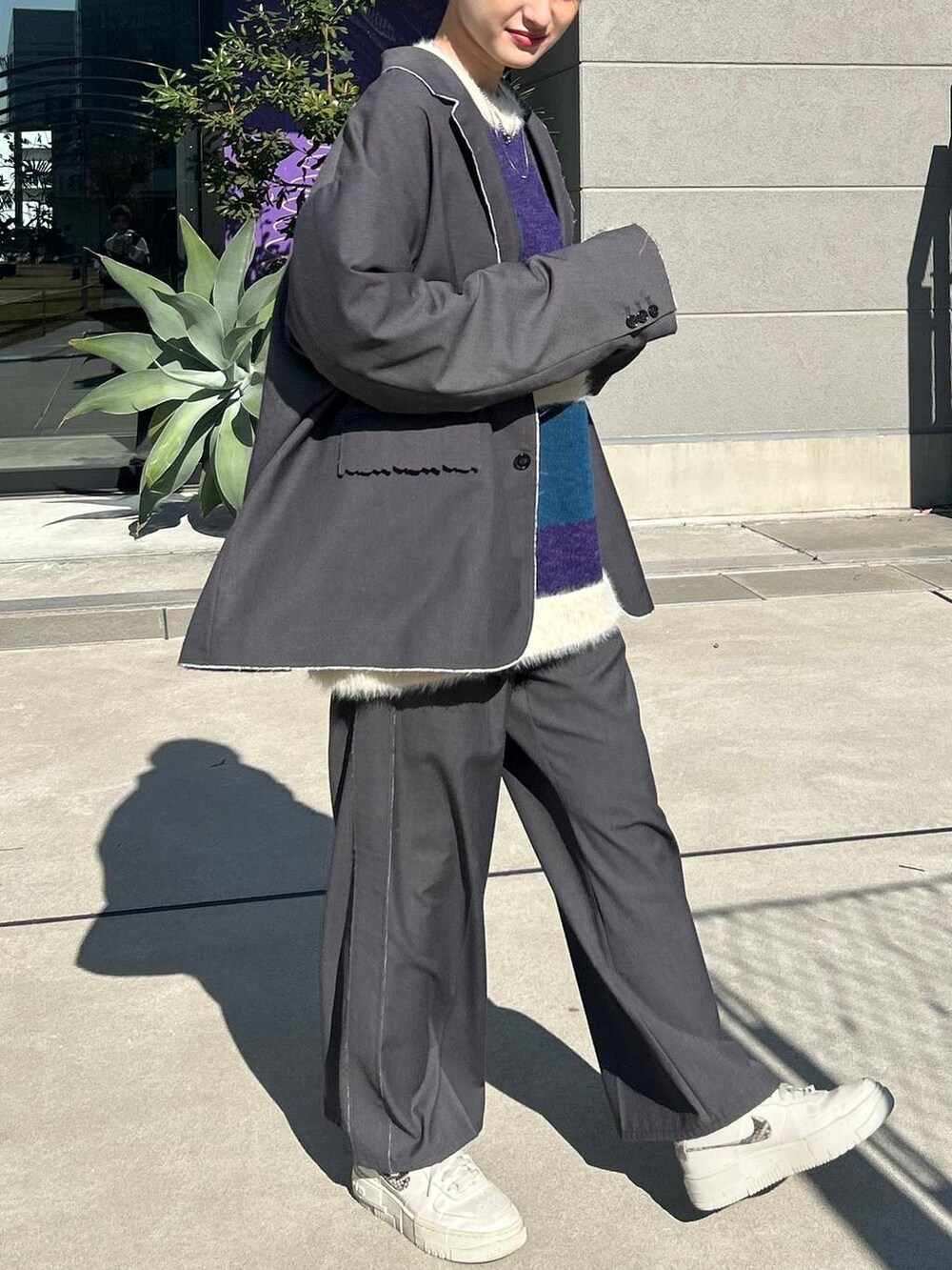 グレー系のスラックス、グレー系のテーラードジャケット、ブルー系のニット/セーターを着用したレディースの冬コーディネートの8枚目の写真