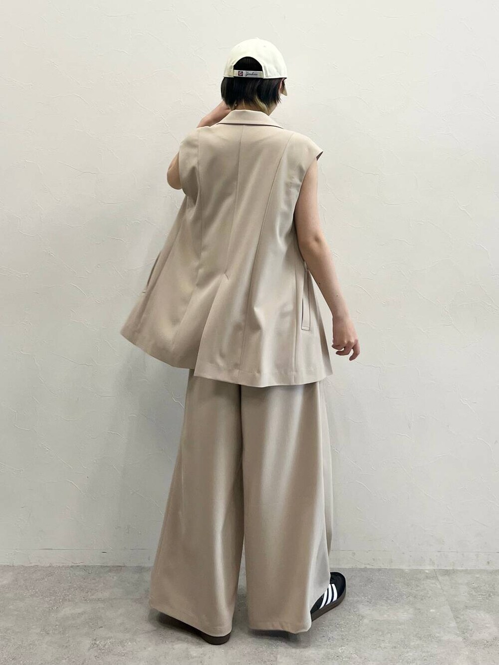 ブラック系のキャミソール、ベージュ系のスラックス、ブラック系のスニーカーを着用したレディースの春コーディネートの5枚目の写真