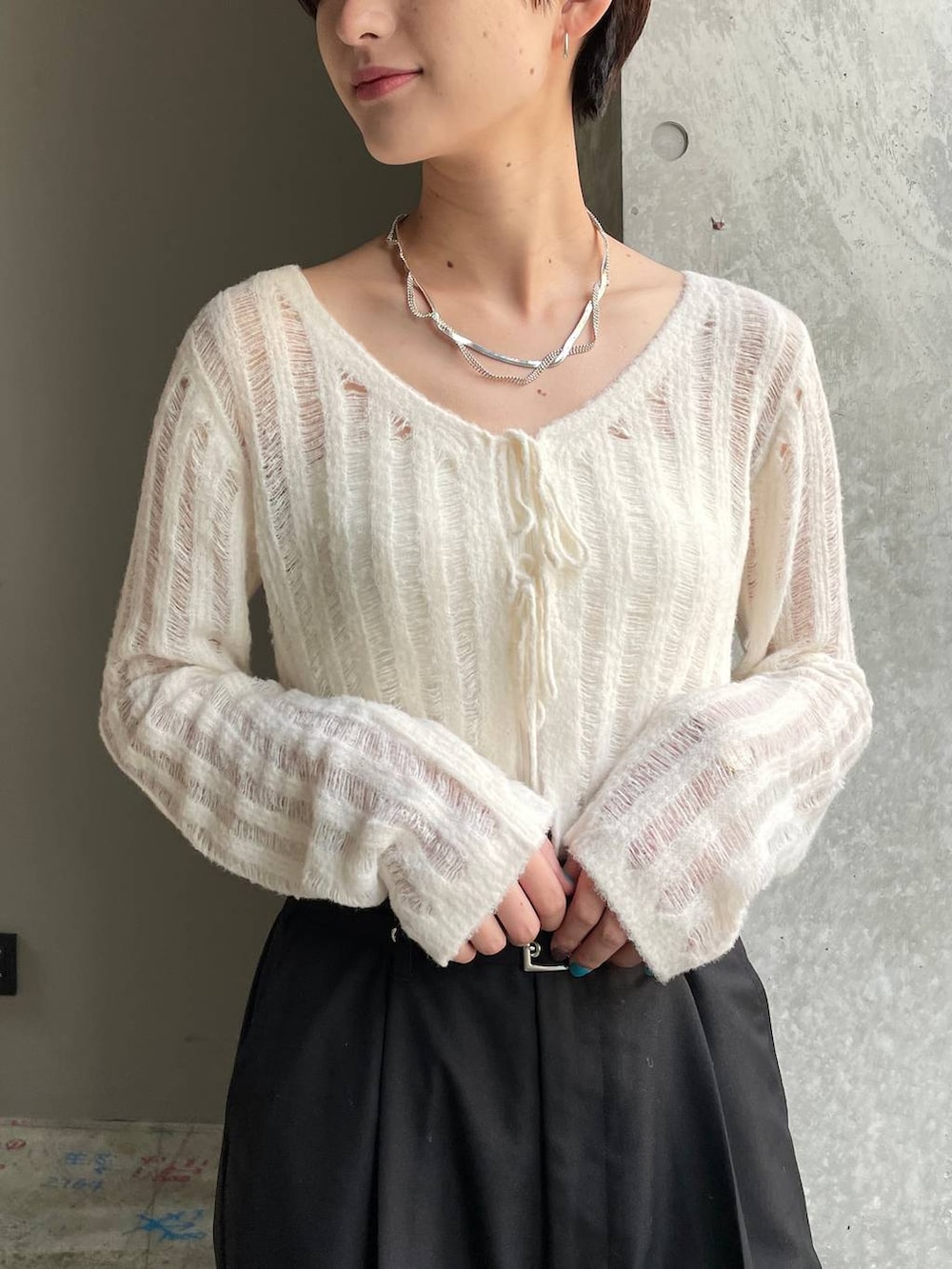 ホワイト系のキャミソール、ブラック系のショルダーバッグ、ホワイト系のカーディガン/ボレロを着用したレディースの冬コーディネートの9枚目の写真