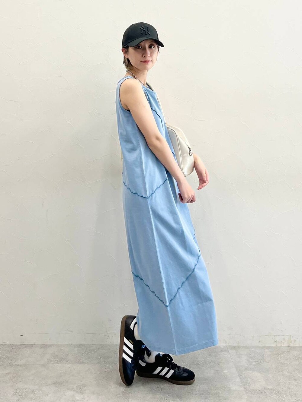 ホワイト系のボストンバッグ、ブラック系のスニーカー、ブルー系のワンピースを着用したレディースの春コーディネートの5枚目の写真