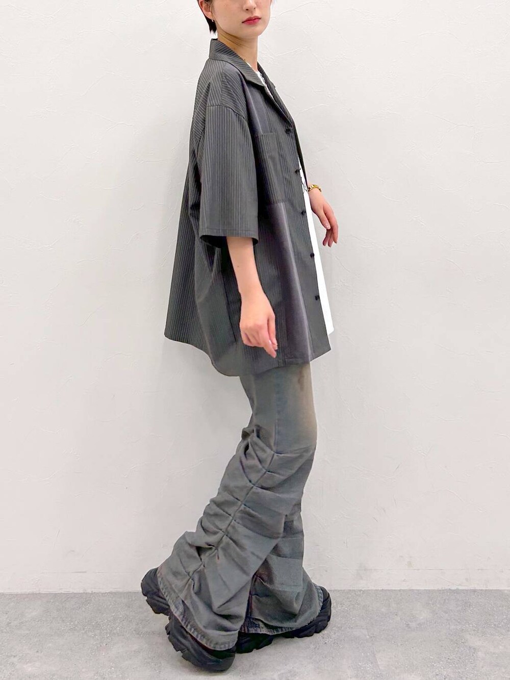 ブラック系のスニーカー、ホワイト系のTシャツ/カットソー、グレー系のシャツ/ブラウスを着用したレディースの夏コーディネートの6枚目の写真