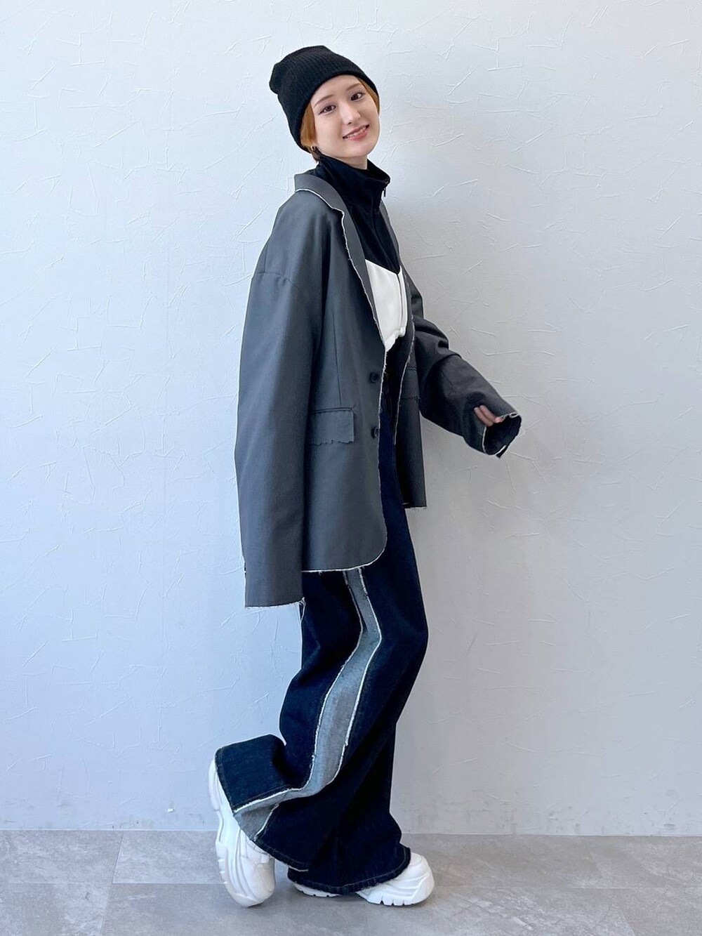 ブルー系のデニムパンツ、グレー系のテーラードジャケット、ブラック系のナイロンジャケットを着用したレディースの秋コーディネートの7枚目の写真