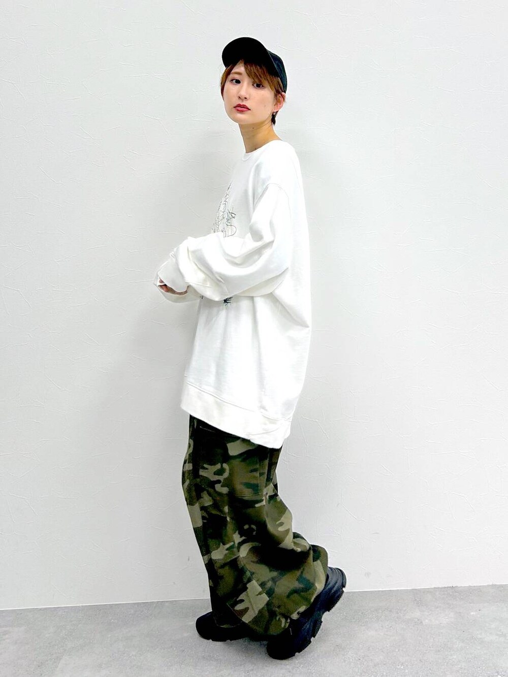 グリーン系のその他パンツ、ホワイト系のスウェット、ブラック系のキャップを着用したレディースの冬コーディネートの3枚目の写真