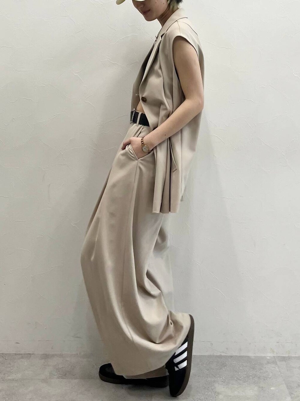 ブラック系のキャミソール、ベージュ系のスラックス、ブラック系のスニーカーを着用したレディースの春コーディネートの4枚目の写真