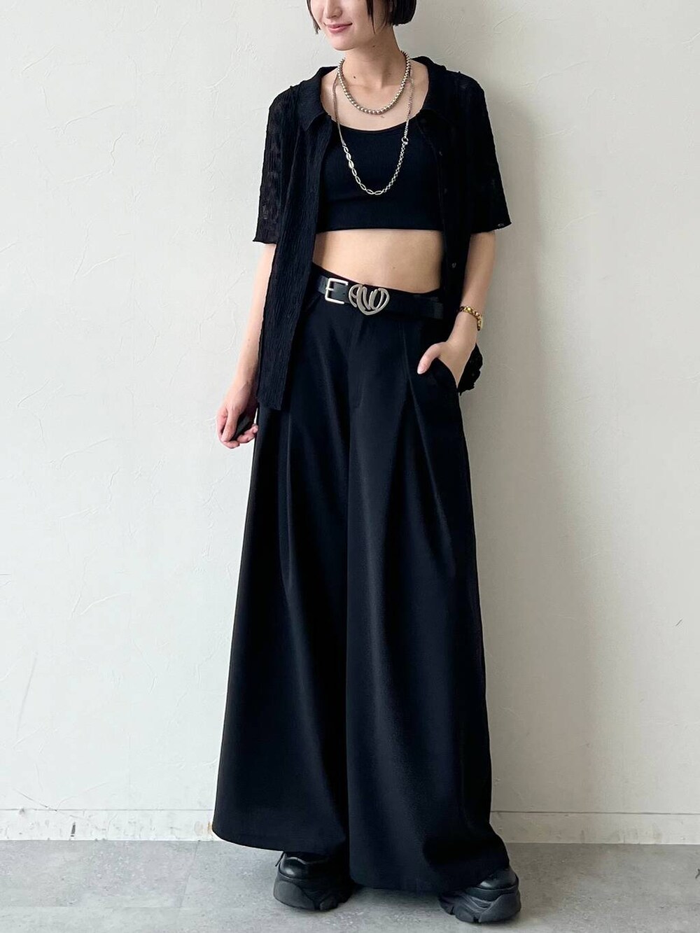 ブラック系のスニーカー、ブラック系のキャミソール、ブラック系のスラックスを着用したレディースの夏コーディネートの2枚目の写真