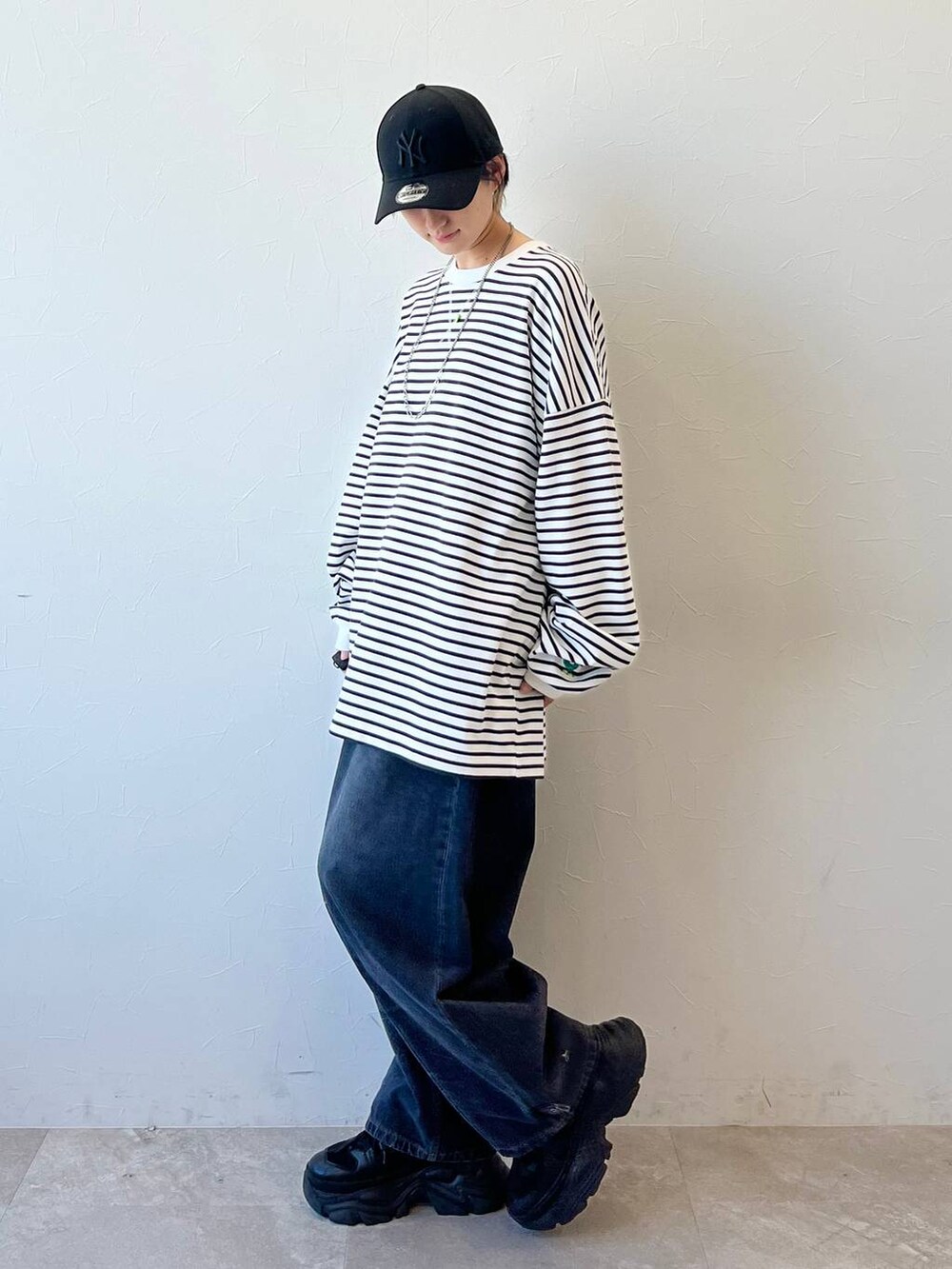 ブラック系のスニーカー、ブラック系のデニムパンツ、ブラック系のキャップを着用したレディースの春コーディネートの4枚目の写真