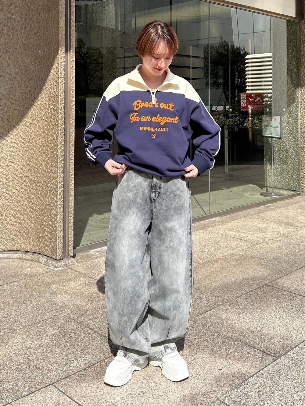 ブルー系のスウェット、ブラック系のデニムパンツを着用したレディースの春コーディネートの2枚目の写真