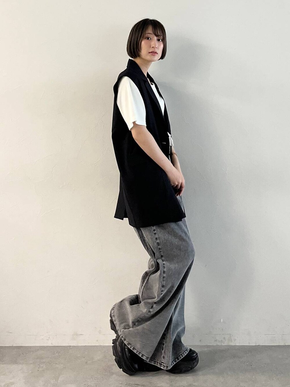 ブラック系のスニーカー、ブラック系のデニムパンツ、ブラック系のその他アウターを着用したレディースの春コーディネートの8枚目の写真