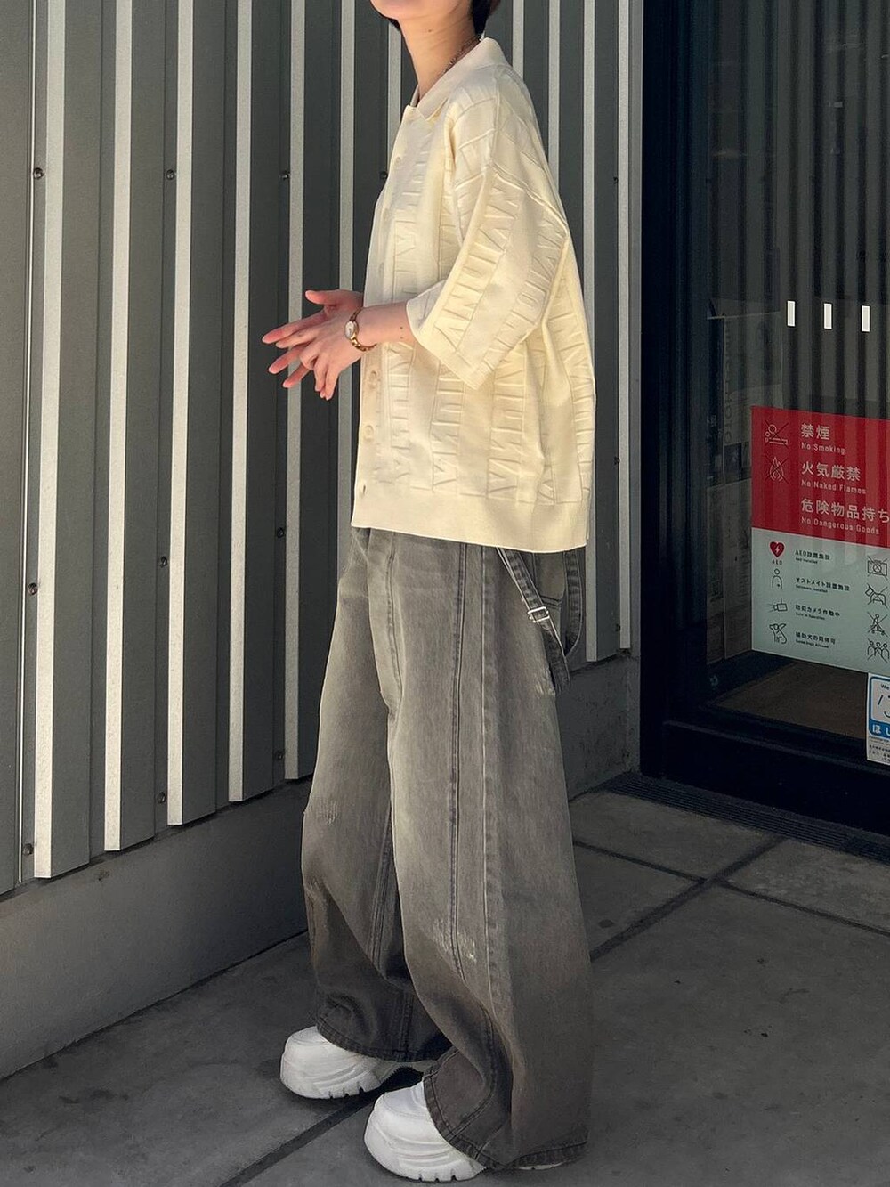 ブラック系のデニムパンツ、ホワイト系のニット/セーターを着用したレディースの春コーディネートの4枚目の写真