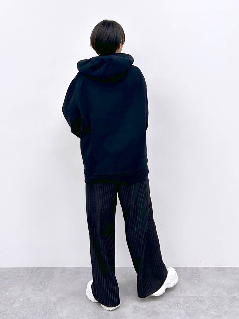 ブラック系のスラックス、ブラック系のパーカーを着用したレディースの秋コーディネートの6枚目の写真