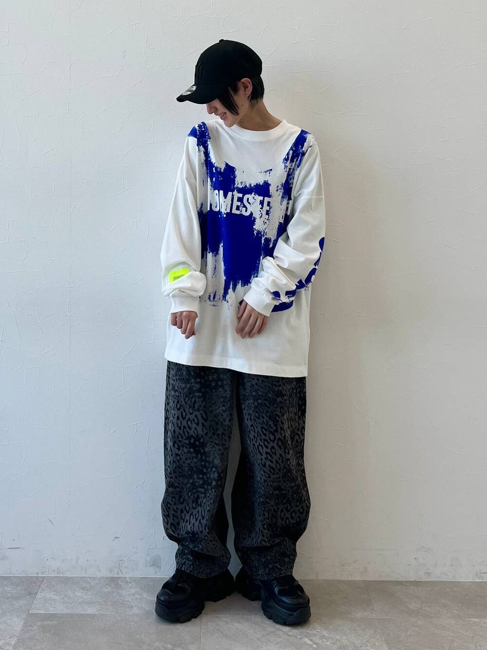 ブラック系のスニーカー、ブラック系のデニムパンツ、ブラック系のキャップを着用したレディースの春コーディネートの3枚目の写真