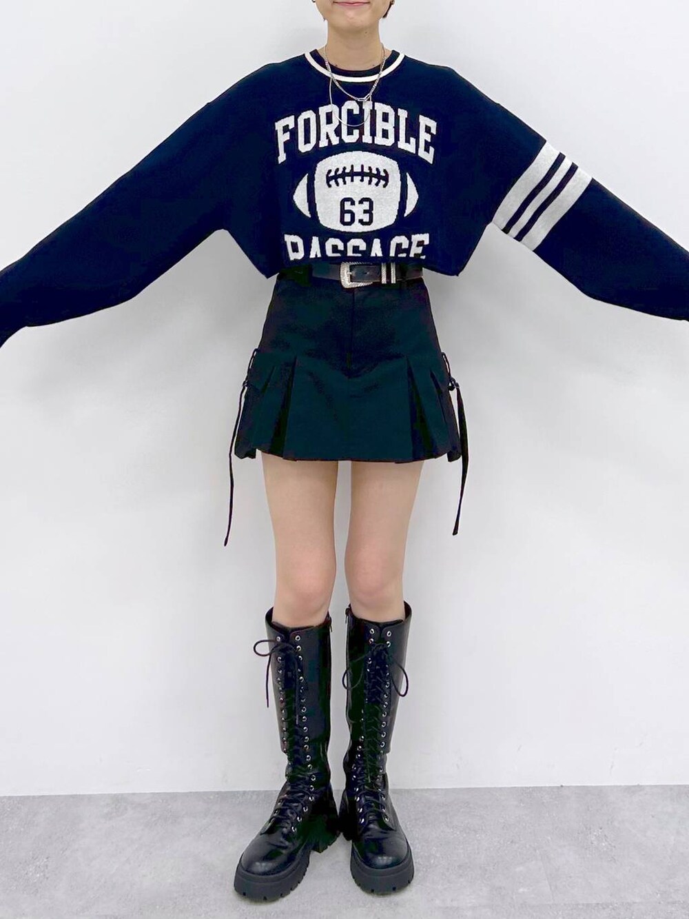 ブラック系のブーツ、ブラック系のスカート、ブルー系のニット/セーターを着用したレディースの冬コーディネートの2枚目の写真