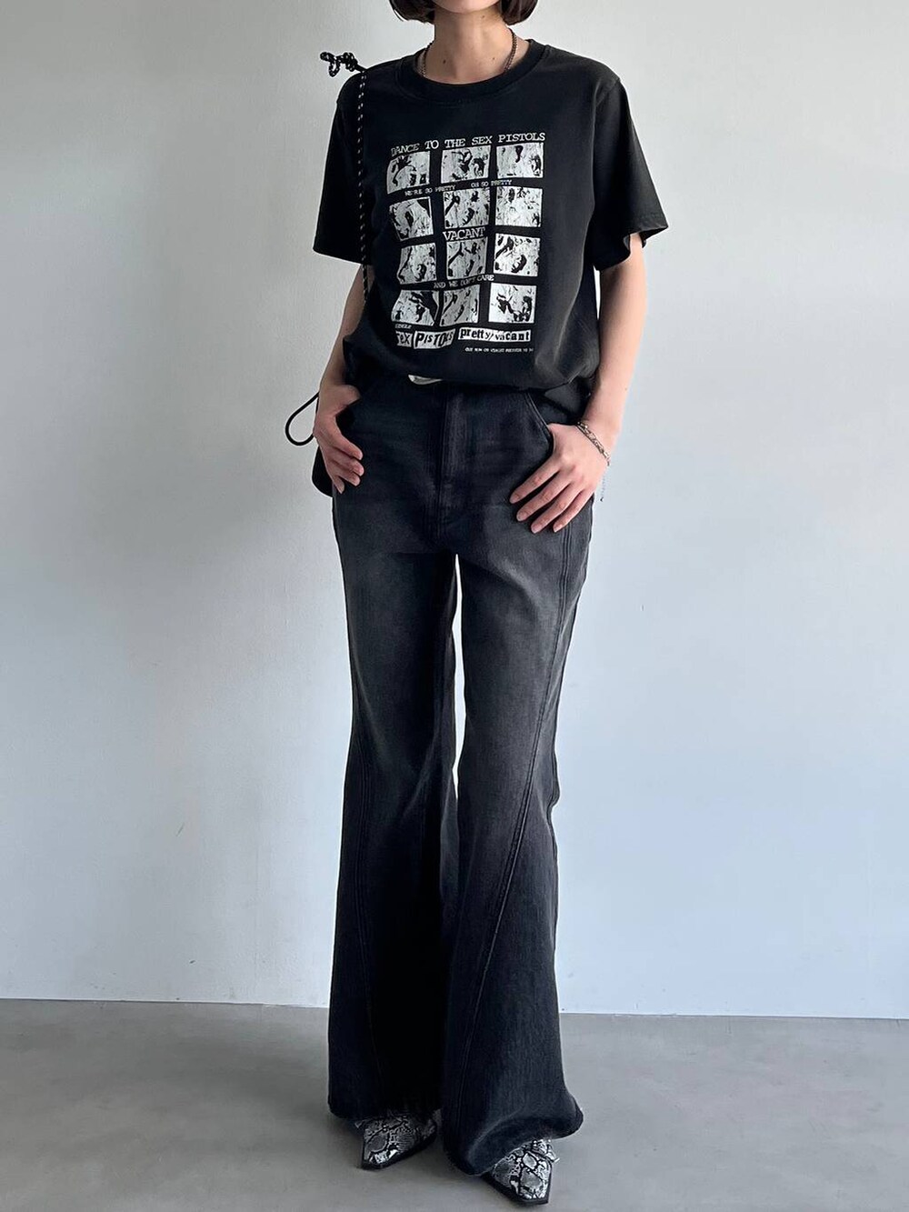 ブラック系のデニムパンツ、ホワイト系のパンプス、ブラック系のTシャツ/カットソーを着用したレディースの夏コーディネートの4枚目の写真