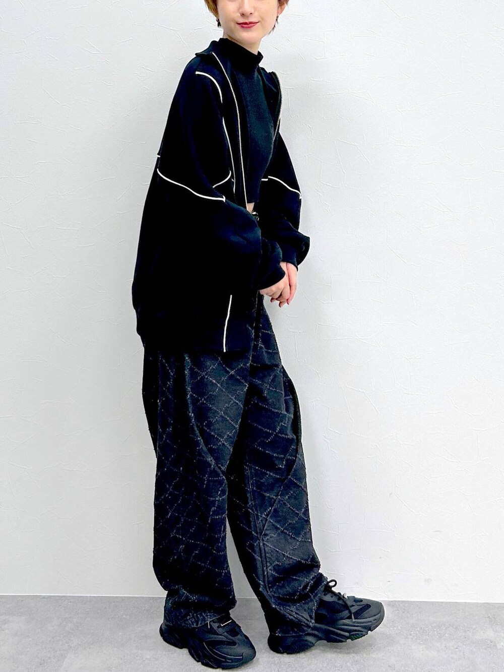 ブラック系のスウェット、ブラック系のデニムパンツ、ブラック系のベルトを着用したレディースの冬コーディネートの7枚目の写真