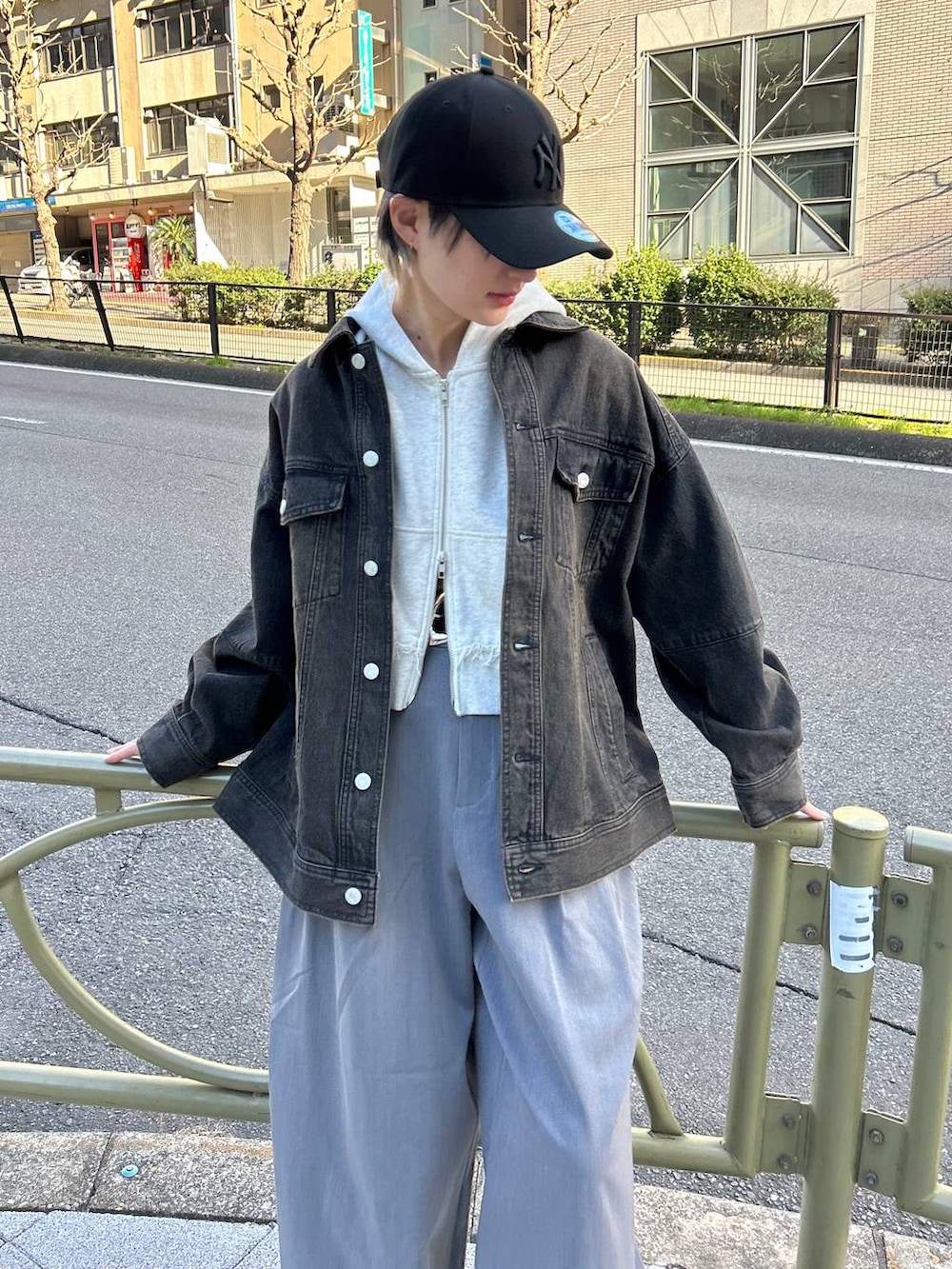 グレー系のスラックス、ベージュ系のパーカー、ブラック系のデニムジャケットを着用したレディースの春コーディネートの3枚目の写真
