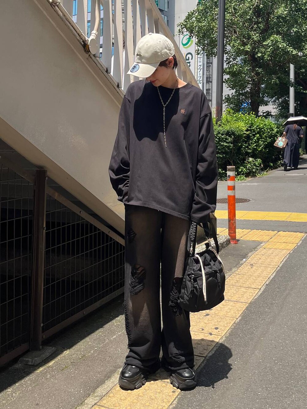 ブラック系のショルダーバッグ、ブラック系のスニーカー、ブラック系のスウェットパンツを着用したレディースの秋コーディネートの3枚目の写真