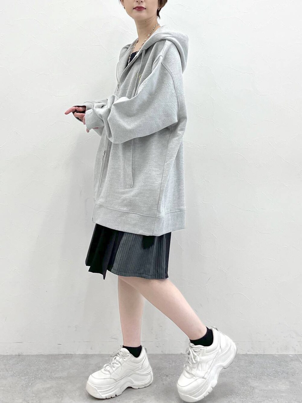 グレー系のパーカー、ブラック系のスラックスを着用したレディースの春コーディネートの4枚目の写真