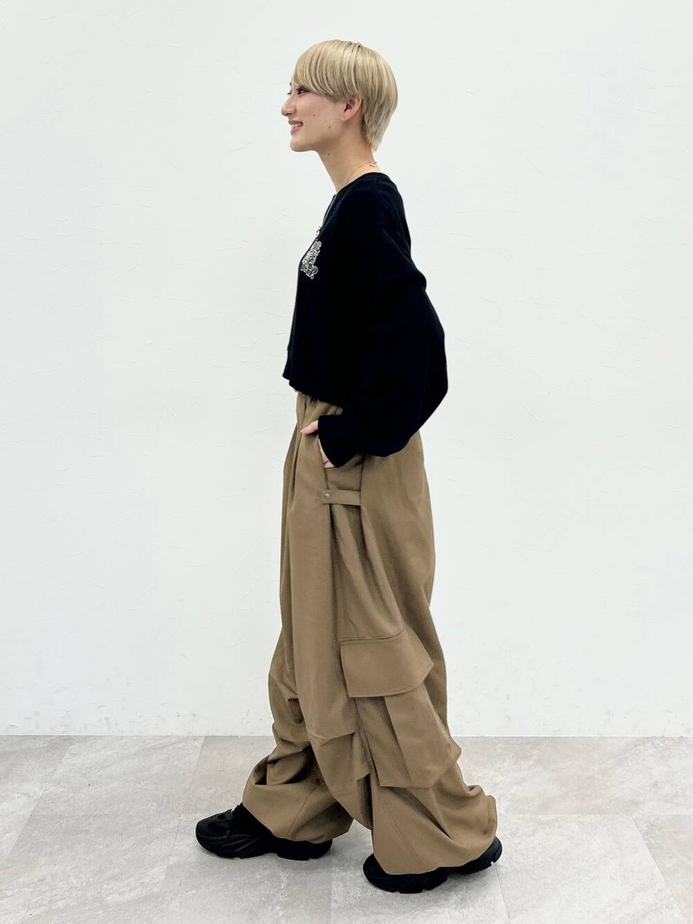 ブラック系のスウェット、ベージュ系のカーゴパンツ、シルバー系のネックレスを着用したレディースの秋コーディネートの4枚目の写真