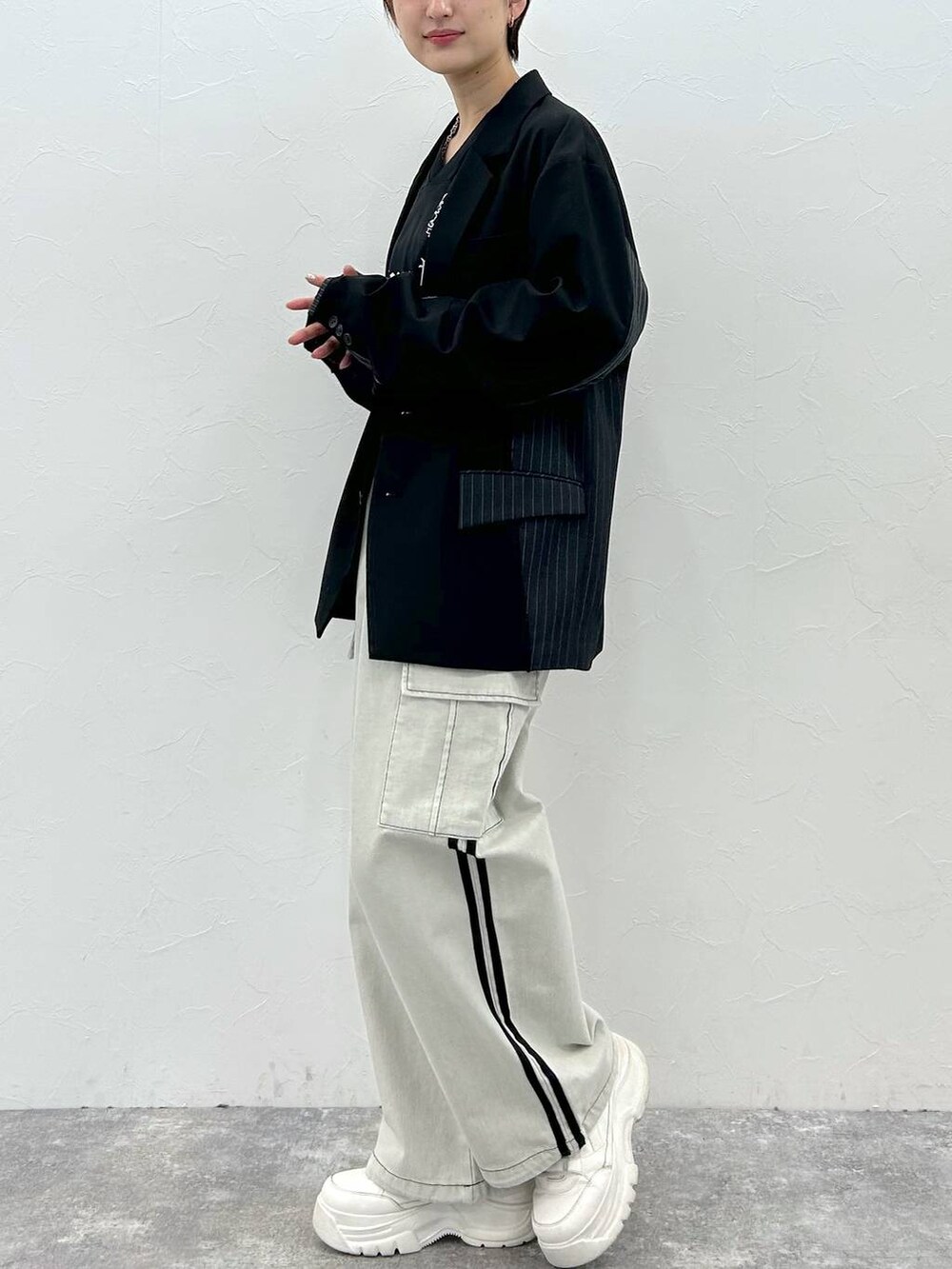 ブラック系のテーラードジャケット、ホワイト系のデニムパンツ、ブラック系のTシャツ/カットソーを着用したレディースの春コーディネートの5枚目の写真