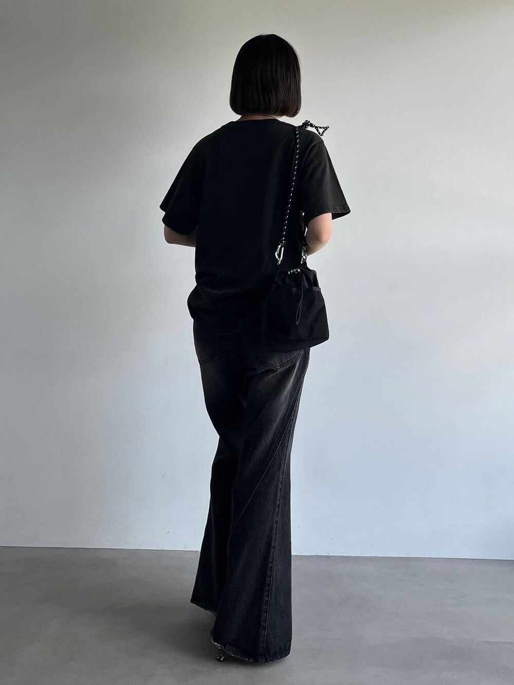 ブラック系のデニムパンツ、ホワイト系のパンプス、ブラック系のTシャツ/カットソーを着用したレディースの夏コーディネートの6枚目の写真