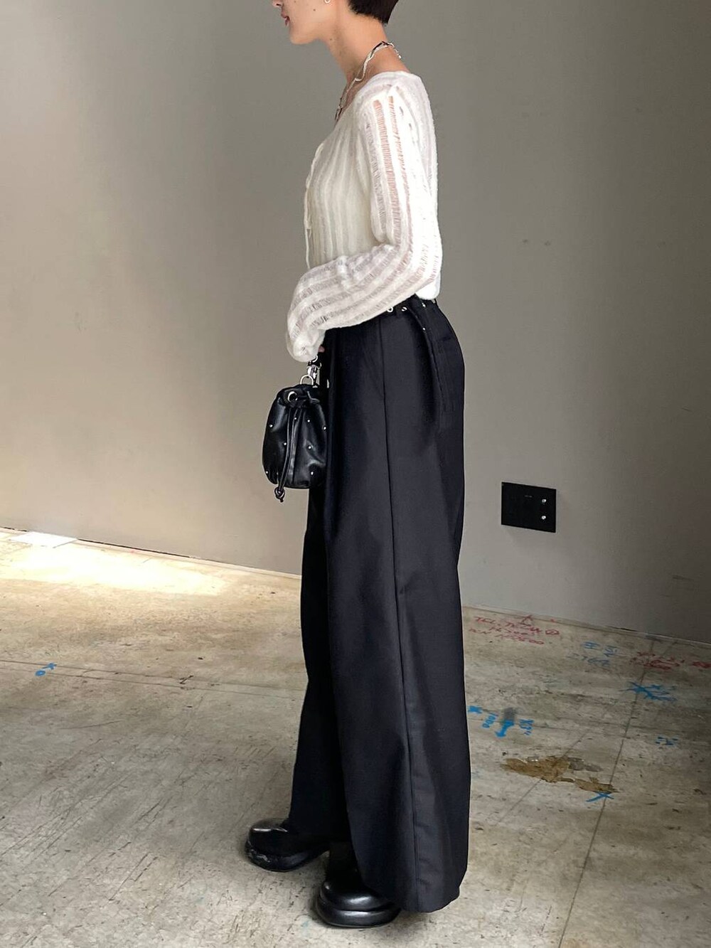 ホワイト系のキャミソール、ブラック系のショルダーバッグ、ホワイト系のカーディガン/ボレロを着用したレディースの冬コーディネートの5枚目の写真