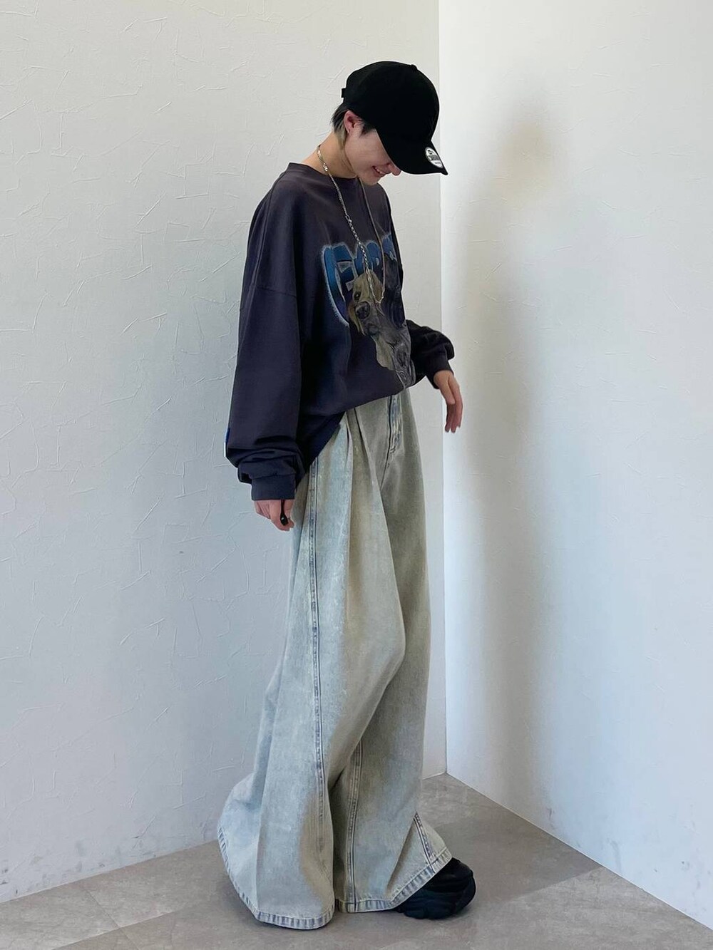 ブラック系のスニーカー、ブルー系のデニムパンツ、ブラック系のキャップを着用したレディースの春コーディネートの3枚目の写真