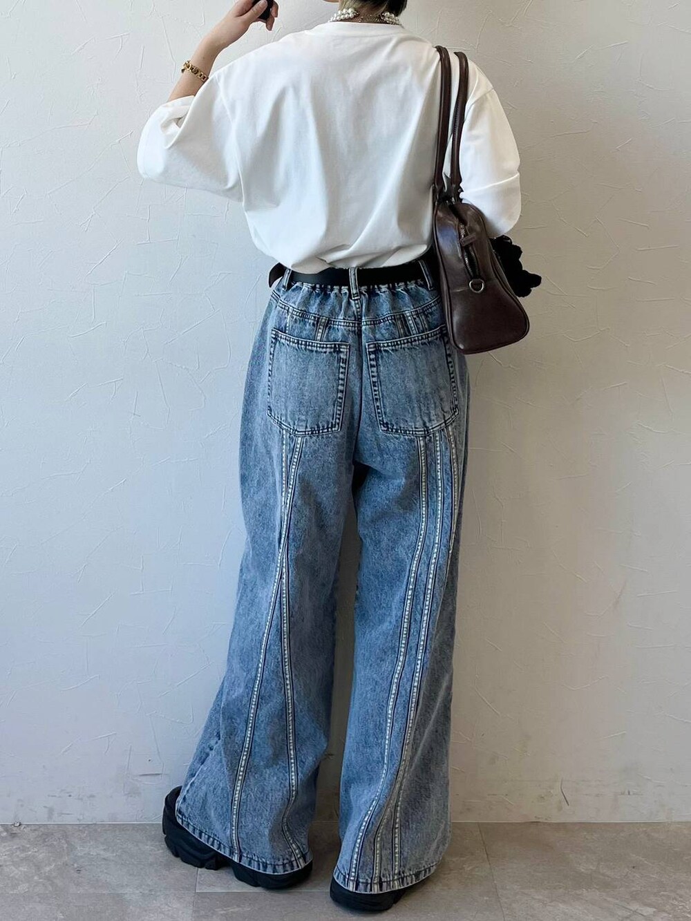 ブラック系のスニーカー、ホワイト系のTシャツ/カットソー、ブラウン系のボストンバッグを着用したレディースの春コーディネートの7枚目の写真
