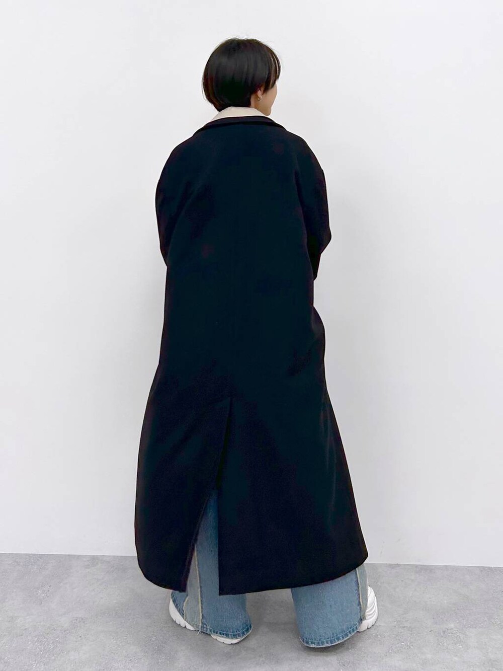 イエロー系のニット/セーター、ブルー系のデニムパンツ、ブラック系のその他アウターを着用したレディースの秋コーディネートの7枚目の写真