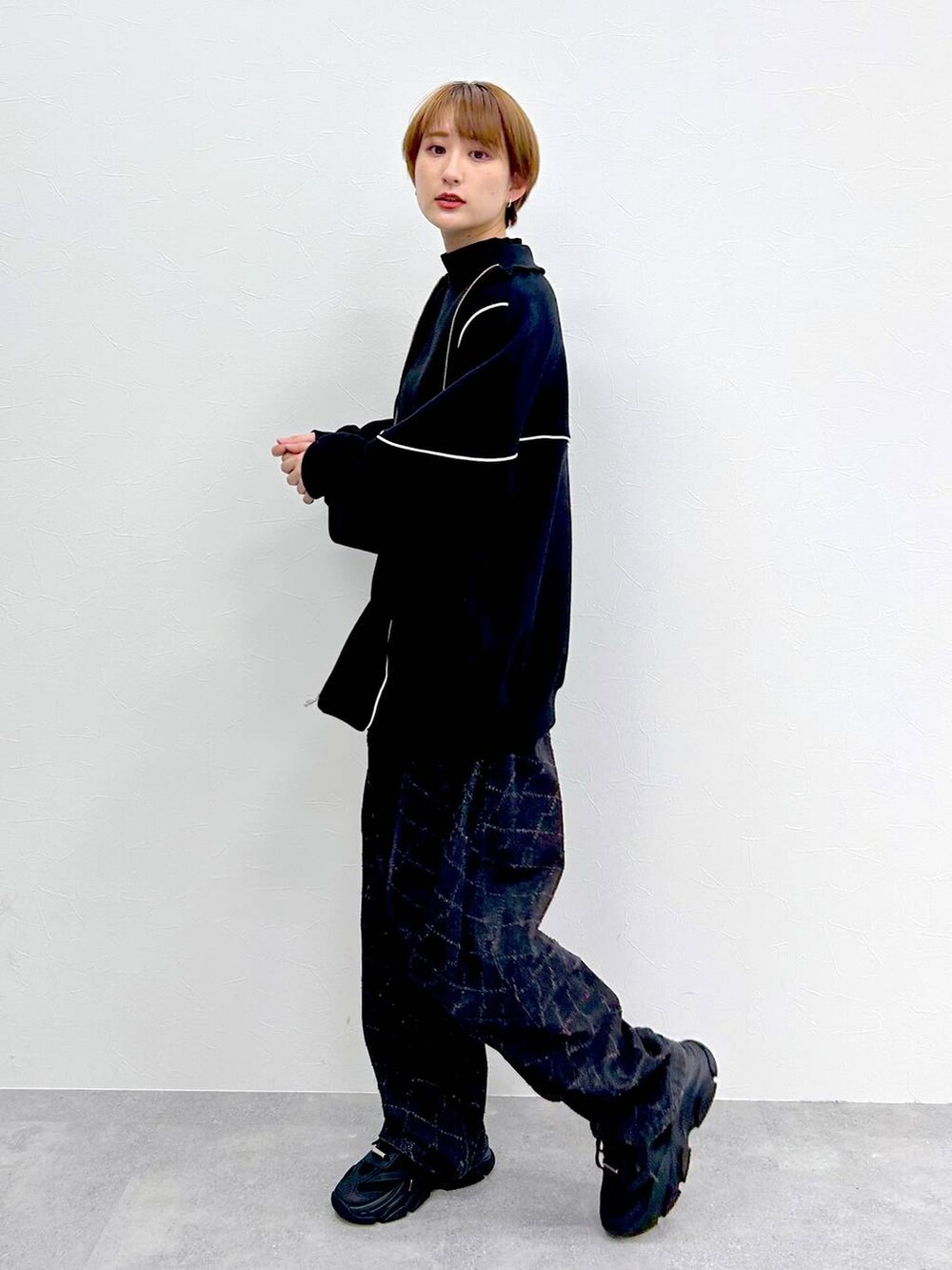 ブラック系のスウェット、ブラック系のデニムパンツ、ブラック系のベルトを着用したレディースの冬コーディネートの4枚目の写真